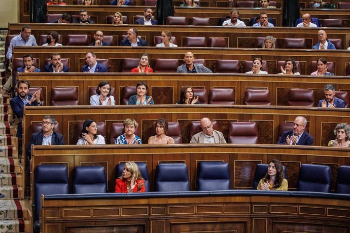 La vicepresidenta segunda y ministra de Trabajo y Economía Social, Yolanda Díaz (i) y la ministra de Justicia, Pilar Llop (d), aplauden durante una sesión plenaria, en el Congreso