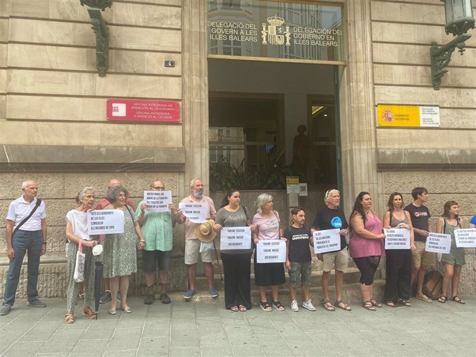 Miembros de la Plataforma contra la ampliación del Aeropuerto de Palma con carteles en la Delegación del Gobierno en Baleares.