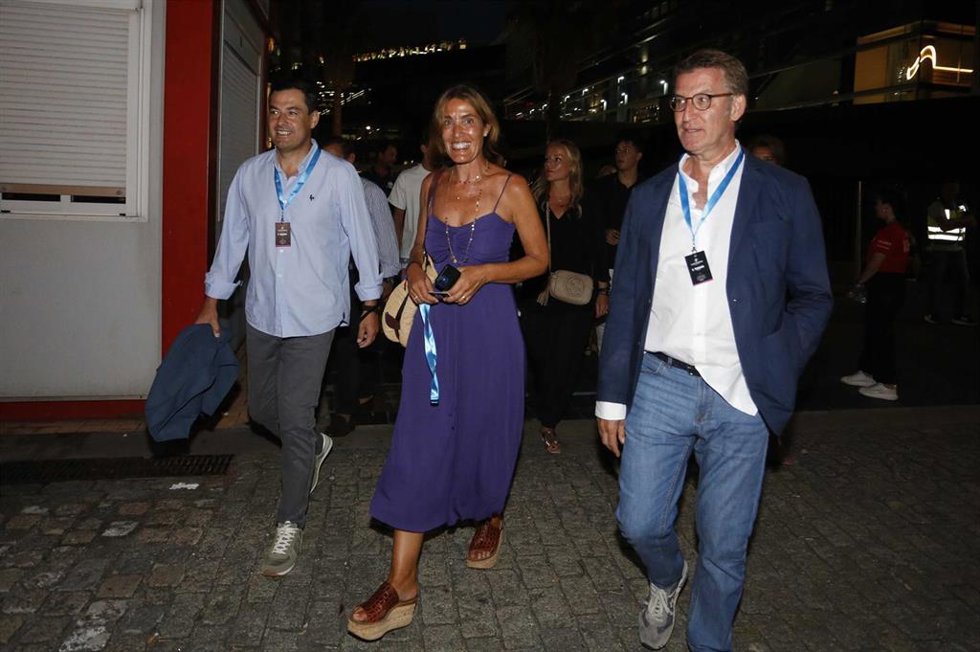 El presidente de la Junta de Andalucía, Juanma Moreno (i1); la empresaria Eva Cárdenas, esposa de Alberto Núñez Feijóo; y el presidente del PP, Alberto Núñez Feijóo; asisten al concierto del cantante C Tangana, en el muelle de Trasatlánticos de Vigo, a