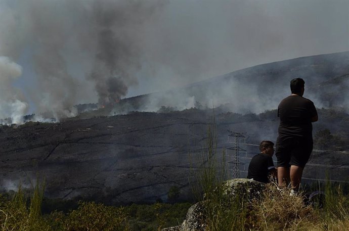 Dos personas de Grou observan el incendio forestal en la Serra do Leboreiro, en Senderiz, en el parque natural de Baixa Limia e Serra do Xurés, a 26 de agosto de 2022, en Serra do Xurés, Ourense