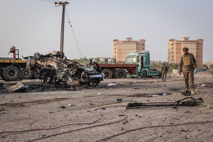 Archivo - 24 March 2022, Yemen, Aden: A member of the Yemeni security personnel inspects a destroyed vehicle in the aftermath of a car bomb attack, which took place a day earlier killing a senior Yemeni military leader along with at least four other peo