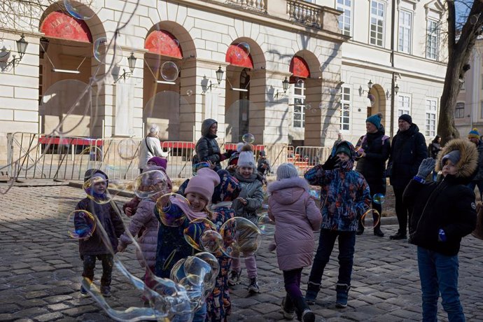 Archivo - 13 de marzo de 2022, Lviv, Ucrania: Se ven niños jugando con burbujas de jabón en el centro de la ciudad de Lviv. Los civiles de Lviv intentan vivir su vida cotidiana a pesar del ataque con bombas ruso de esta mañana contra una base militar en