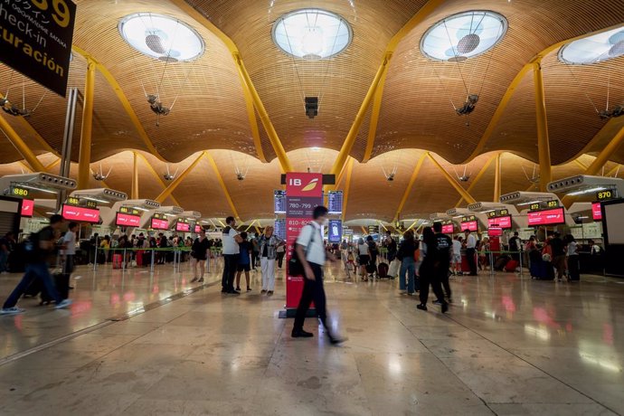 Varios pasajeros esperan para obtener sus tarjetas de embarque y facturar su equipaje  en salidas de la T4 del Aeropuerto Adolfo Suárez Madrid-Barajas, a 28 de agosto de 2022, en Madrid (España). 