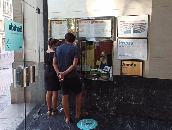 Un hombre y una mujer comprando una entrada del Teatre Principal de Palma.