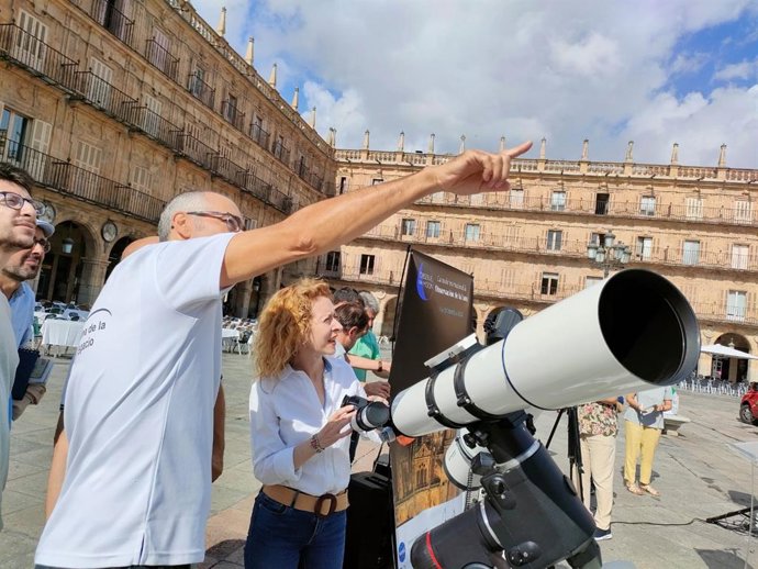 La concejal Ana Suárez observa el cielo con un telescopio en la Plaza Mayor de Salamanca.