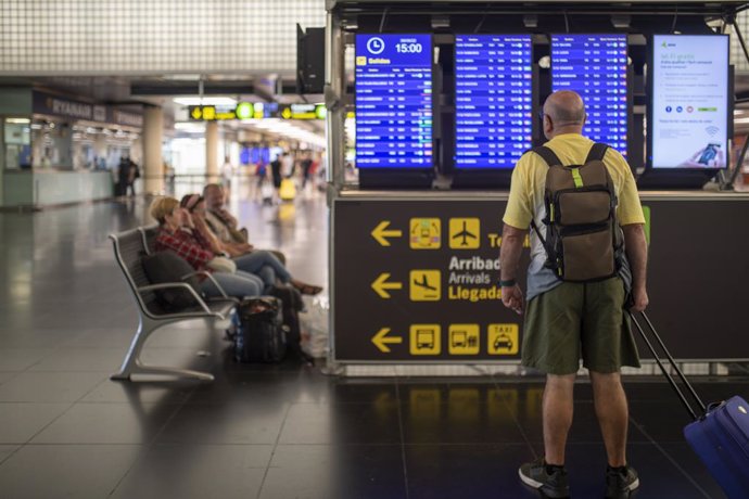 Un hombre mira un panel de llegadas y salidas en el Aeropuerto Josep Tarradellas Barcelona-El Prat, a 8 de agosto de 2022, en Barcelona, Catalunya (España).  Se reanudan hoy las nuevas jornadas de huelga de los tripulantes de cabina de pasajeros (TCP) e