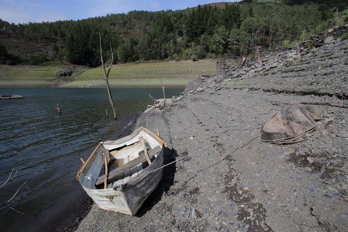 Una barca de madera en el embalse con poco caudal, a 26 de agosto de 2022, en Negueira de Muñiz, Lugo, Galicia (España). 