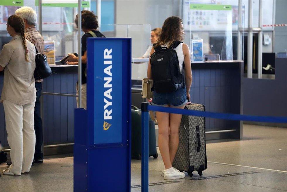 Turistas hacen colas en los puestos de embarque de Ryanair.