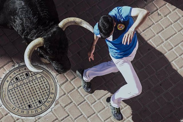 Imagen de un corredor delante de uno de los toros en el quinto encierro de las fiestas del Cristo de los Remedios de San Sebastián de los Reyes