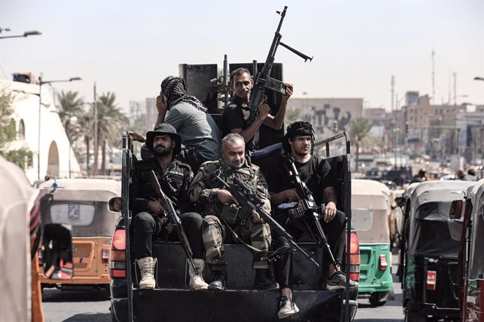 30 August 2022, Iraq, Baghdad: Armed members of Saraya al-Salam, the military wing linked to Iraqi Shiite cleric Muqtada Al-Sadr ride a vehicle during clashes with Iraqi security forces in Iraq's Green Zone. Iraqi medical and security sources reported t