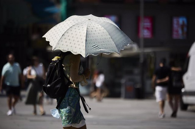Archivo - Una persona se protege del sol con un parasol, a 12 de julio de 2022, en Madrid (España). La segunda ola de calor del verano podría alcanzar temperaturas máximas de hasta 47 grados centígrados (C) en algunos puntos de la península. En Madrid,