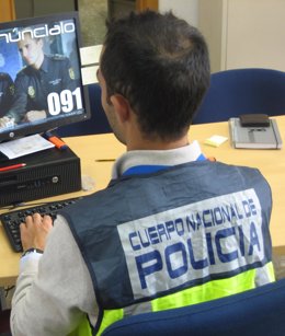 Archivo - Agente de la Policía Nacional frente a un ordenador, en una imagen de archivo