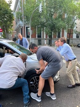 El alcalde de Madrid, José Luis Martínez.Almeida ayuda, a empujar a un coche que quedó en medio de la calle Velázquez tras chocar con un taxi