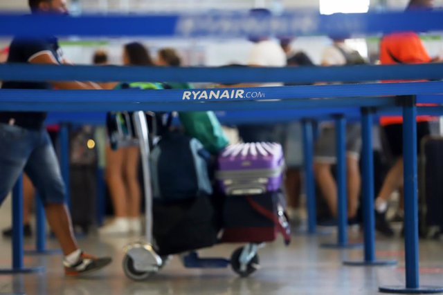 Cientos de turistas hacen colas en los puestos de embarque de Ryanair, en el Aeropuerto Costa del Sol, en Málaga, Andalucía.
