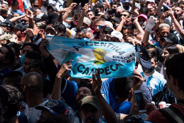 Archivo - Una multitud sostiene una bandera de la victoria de Argentina en el Mundial de Fútbol de 1986 
