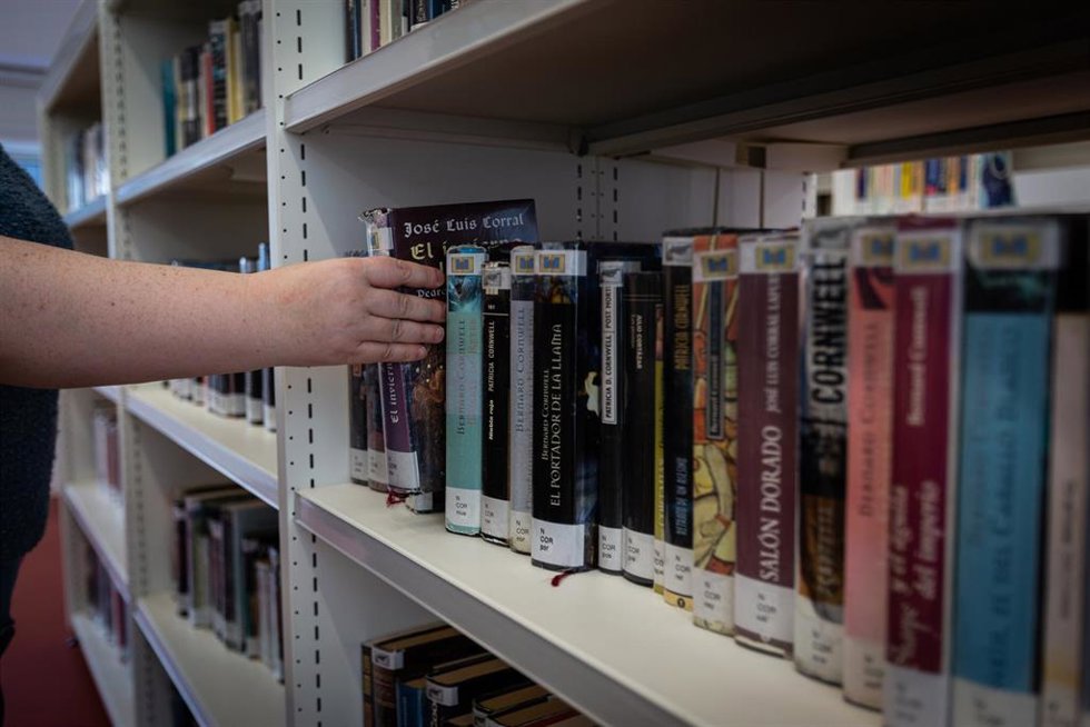 Archivo - Una persona coge un libro de la estantería de una librería