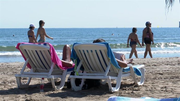 Archivo - Turistas en una playa valenciana (archivo)