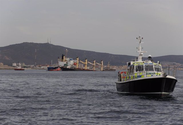 Una patrullera de la policía en Gibraltar con el OS35 de fondo semihundido.