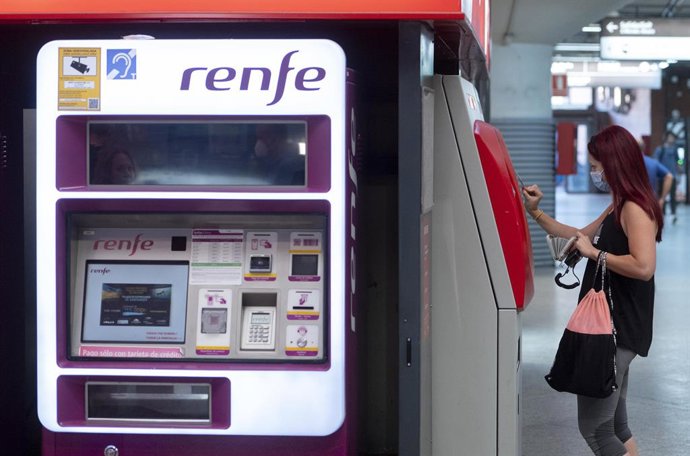Una dona compra el bitllet a les taquilles de venda automtica d'una estació de tren 