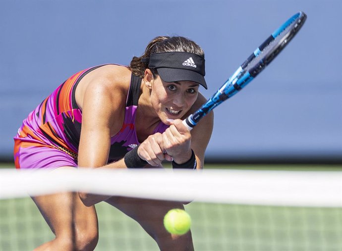 30 August 2022, US, Flushing Meadows: Spanish tennis player Garbine Muguruza hits a two-handed backhand shot against Denmark's Clara Tauson during their Women's singles First Round of the US Open tennis tournament at USTA Billie Jean King National Tenni