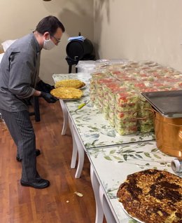 Archivo - Un voluntario de Cáritas prepara comida para su reparto en Córdoba durante la pandemia.