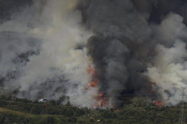 Un helicóptero trabaja en las labores extinción en un incendio en la Serra do Leboreiro, en los montes del pueblo de Senderiz, en el parque natural de Baixa Limia e Serra do Xurés, a 26 de agosto de 2022, en Serra do Xurés, Ourense, Galicia.