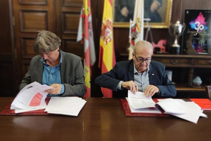 Carlos Martínez (izda) y Modesto Fernández firman el convenio entre Ayuntamiento de Soria y Cruz Roja.
