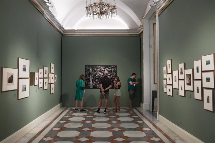 Archivo - Varias personas observa la fotografía del brasileño Salgado, de una isla en Madagascar, en la exposición fotográfica Sebastio Salgado y las Colecciones Reales. Encuentros en torno a la fotografía de paisaje