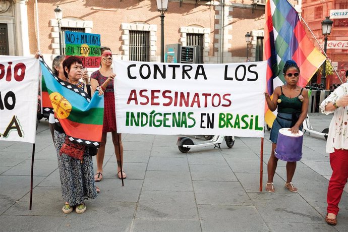 Archivo -  Manifestantes sostienen una pancarta durante una protesta en demanda de justicia para los indígenas asesinados en Brasil celebrada en la plaza de las provincias de Madrid. 