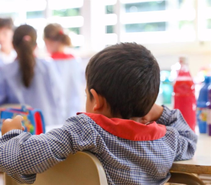 Un niño sentado en su pupitre el día de inicio del curso en el colegio 