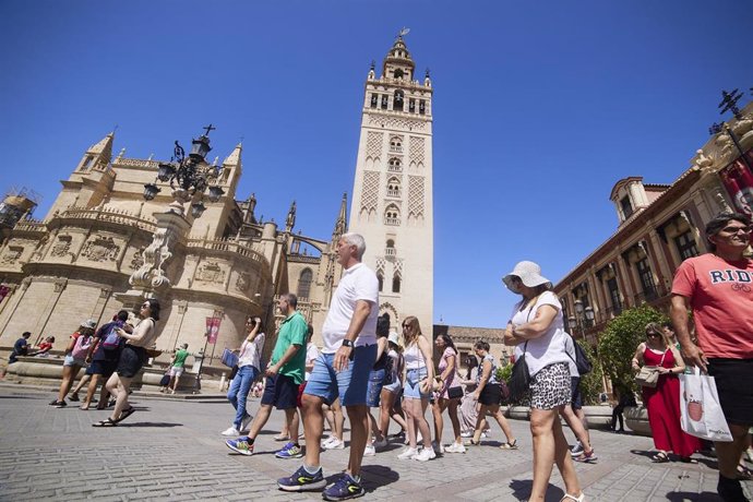Archivo - Un grupo de turistas pasean por la plaza Virgen de los Reyes de Sevilla.
