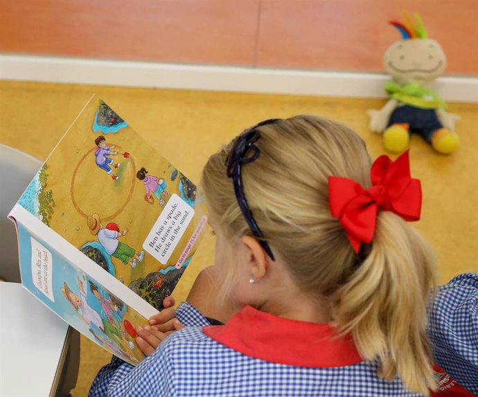 Una niña lee el día de inicio del curso en el colegio de la Alameda de Osuna.