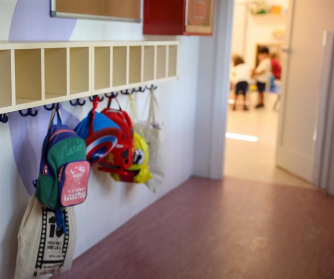 Varias mochilas en una percha de un aula de 0 a 3 años del colegio CEIP Hernán Cortés 