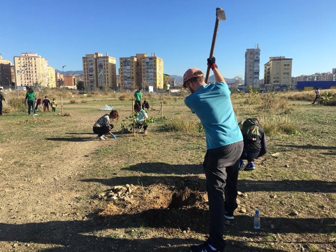 Archivo - Un voluntario planta árboles en los antiguos terrenos de Repsol.
