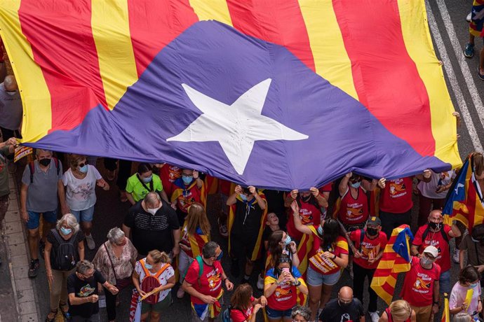 Archivo - Varias personas portan una bandera estelada durante la manifestación organizada por la Asamblea Nacional Catalana (ANC) con motivo de la Diada, día de Cataluña, a 11 de septiembre de 2021, en Barcelona, Catalunya (España). La cabecera de la ma