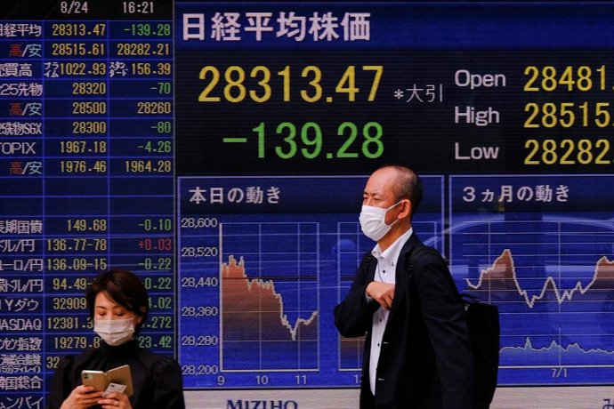 24 August 2022, Japan, Tokyo: People stand in front of an electronic board displaying various countries' stock indexes outside a brokerage in Tokyo. Photo: James Matsumoto/SOPA Images via ZUMA Press Wire/dpa