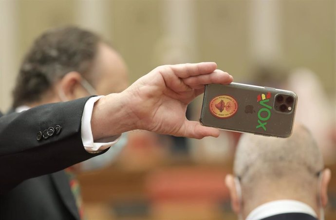 Archivo - Un miembro de Vox realiza una fotografía con su móvil en la Comisión de Interior, a 25 de junio de 2021, en el Congreso de los Diputados.