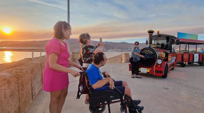 Personas con movilidad reducida asisten a un 'Atardecer en el faro' de Almería.