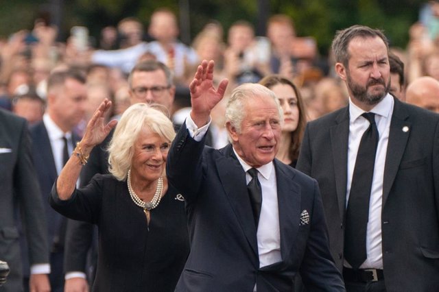 09 September 2022, United Kingdom, London: King Charles III and the Queen Consort wave to the crowd outside Buckingham Palace after travelling from Balmoral following the death of Queen Elizabeth II on Thursday. Photo: Dominic Lipinski/PA Wire/dpa