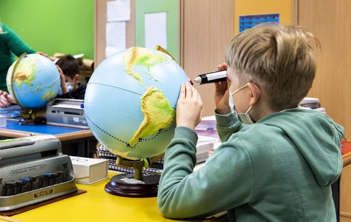 Archivo - Un alumno de primaria utiliza un globo terraqueo adaptado con relieve.