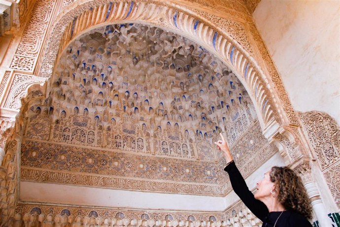 La investigadora de la UGR, Carolina Cardell, muestra el color púrpura de los mocárabes del Patio de los Arrayanes de la Alhambra.
