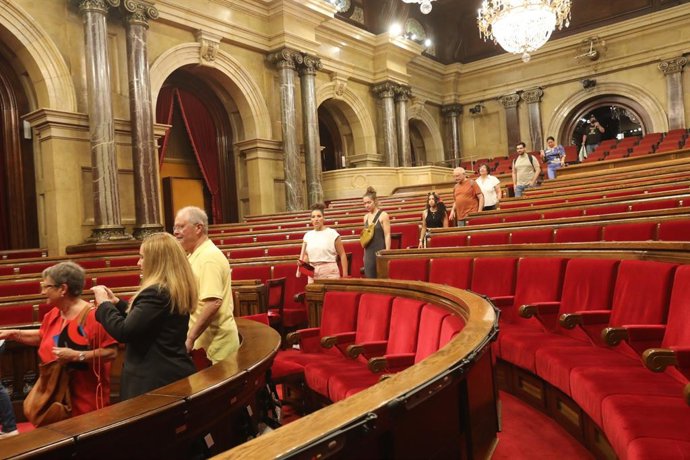 Un grup de persones visita la sala de plens del Parlament de Catalunya durant la seva jornada de portes obertes per la Diada i el seu 90 aniversari