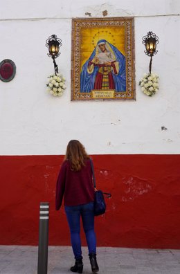 Archivo - Una joven contempla el azulejo de la Virgen de la Hiniesta, imagen de archivo