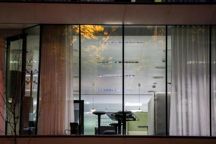 Archivo - Un edificio de oficinas en el que se ve el interior con las luces encendidas.