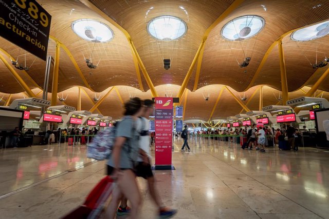 Varios pasajeros esperan para obtener sus tarjetas de embarque y facturar su equipaje en salidas de la T4 del Aeropuerto Adolfo Suárez Madrid-Barajas, a 28 de agosto de 2022, en Madrid (España).