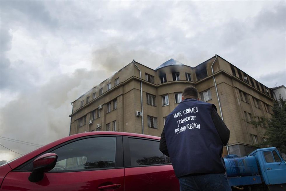Un investigador de crímenes de guerra observa un edificio incendiado tras el ataque de las tropas rusas en Járkov