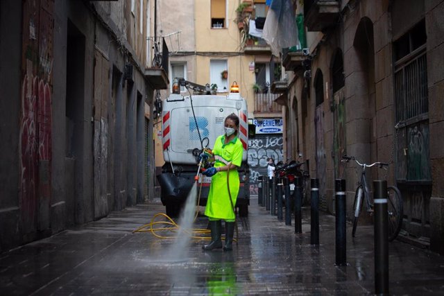Archivo - Una trabajadora limpia una vía de Barcelona, a 26 de julio de 2021, en Barcelona, Catalunya, (España). Con motivo de la temporada estival, Barcelona refuerza con 200 personas su servicio de limpieza y mantenimiento de las zonas verdes de la ci