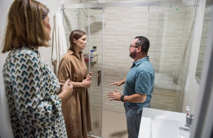 Casanueva (centro) en el cuarto de baño de una de las viviendas donde se ha intervenido en Baena.