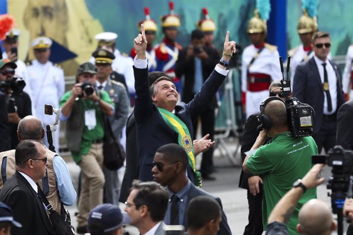 El presidente de Brasil, Jair Bolsonaro (C), estira los brazos hacia el cielo durante las celebraciones por el 200 aniversario de la independencia del país de Portugal. 