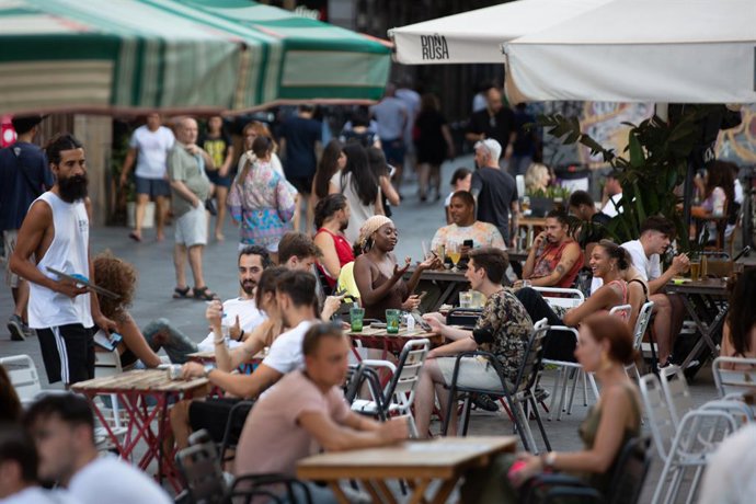 Archivo - Un cambrer i diversos clients en una terrassa d'un bar